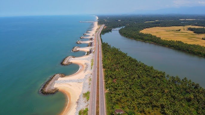 Udupi Beach Top view of Udupi Beach showing golden sand, blue Arabian Sea waves, and lush green coastline of coastal Karnataka